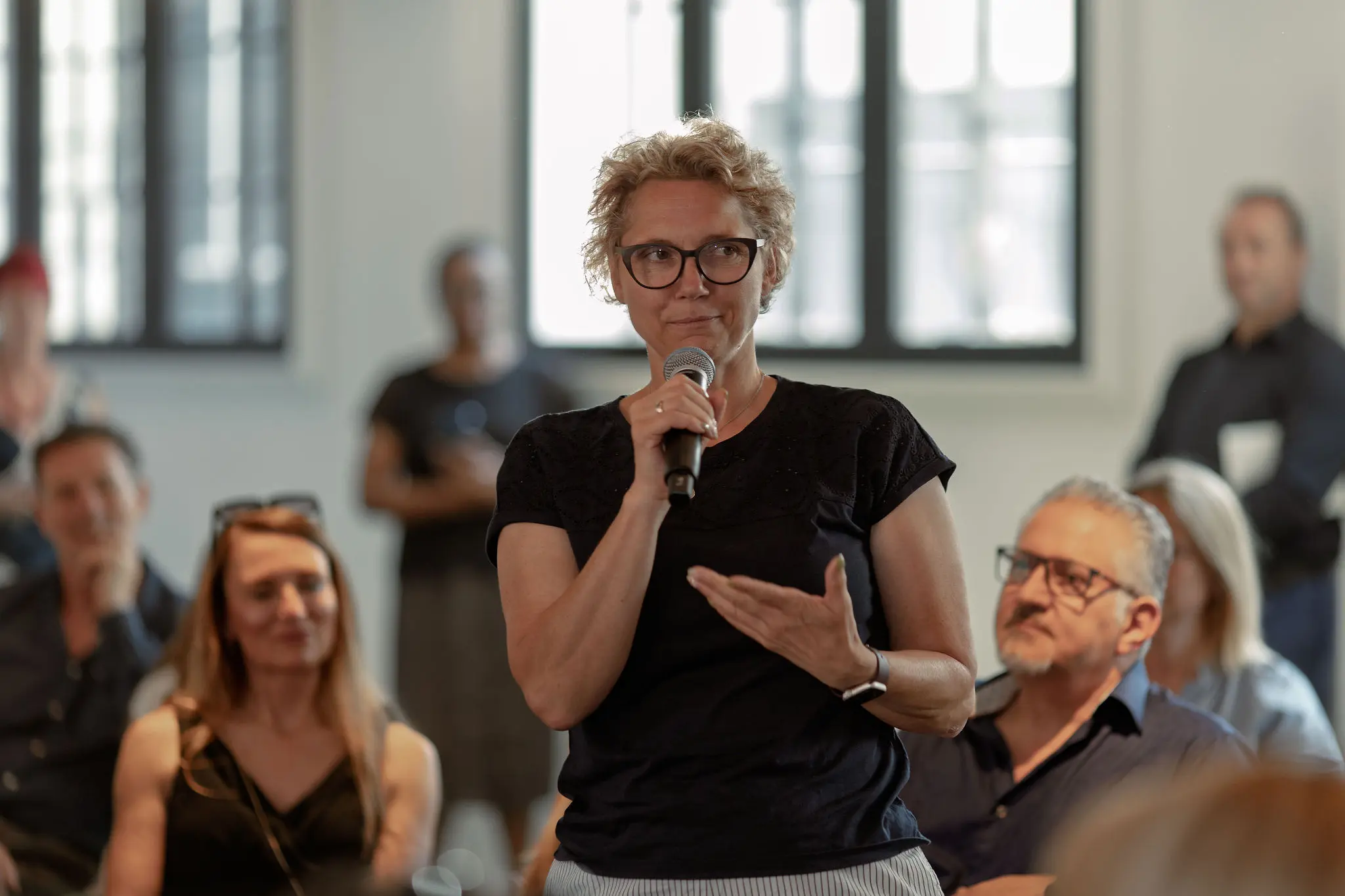 Audience member asking a question during an interactive discussion at a Future Forum event