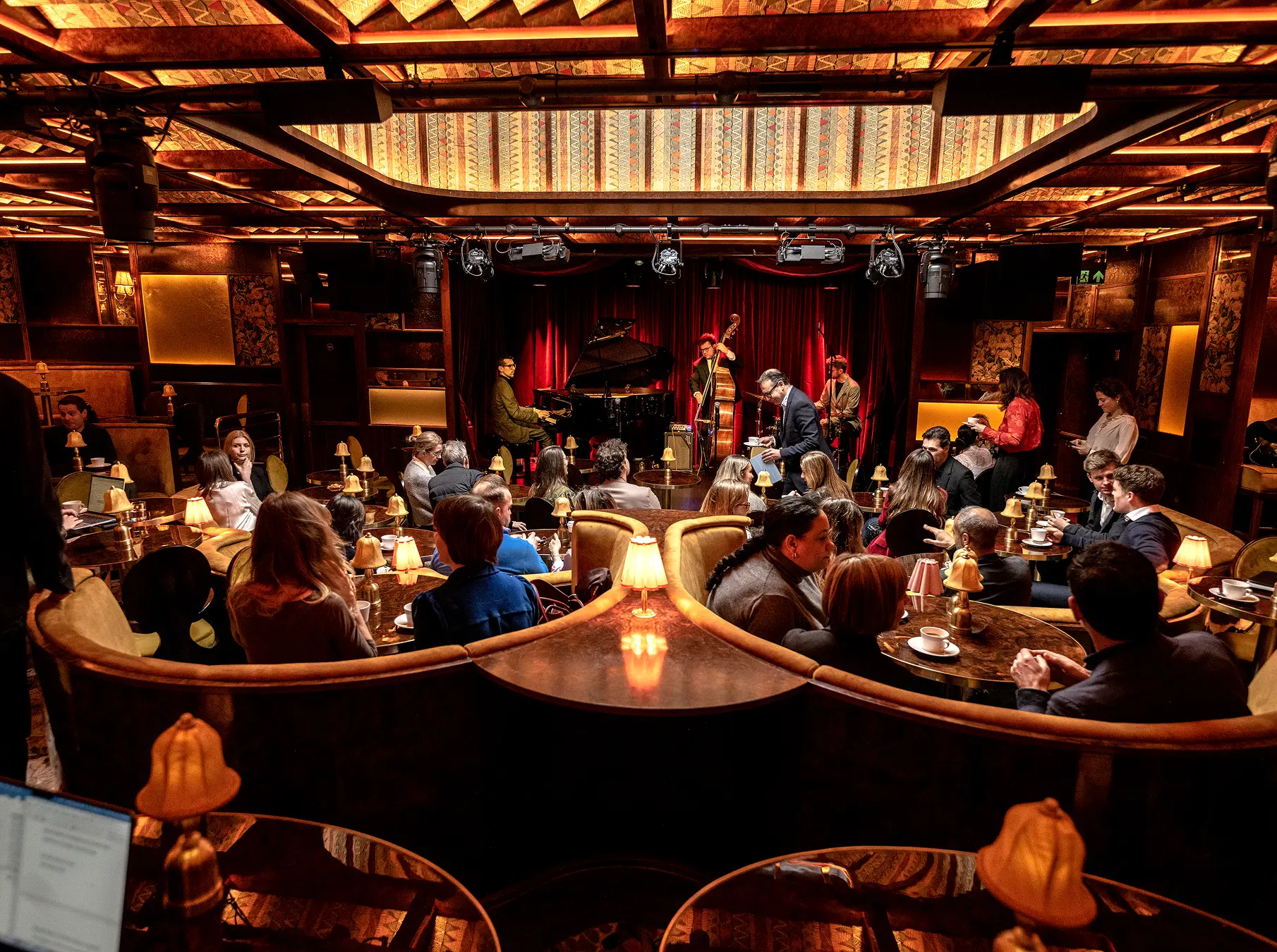 Interior of Ronnie Scott’s Jazz Club in London with musicians performing on stage and guests seated at tables